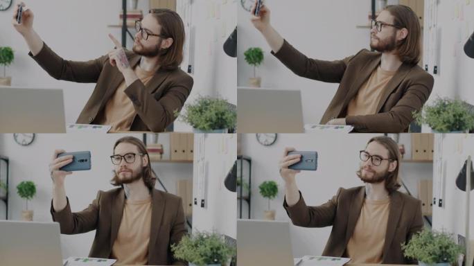 帅哥在办公室为智能手机相机摆姿势自拍的肖像
