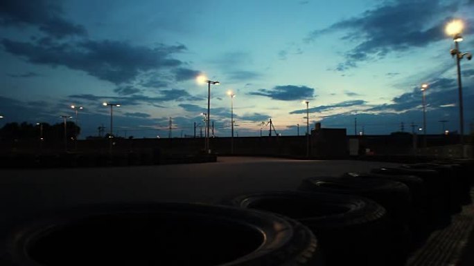 室外卡丁车赛道，汽车在深蓝色的夜空下通过，延时