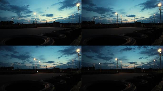 室外卡丁车赛道，汽车在深蓝色的夜空下通过，延时