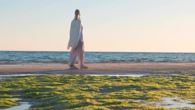 成熟的女人在海滩上享受孤独，日落