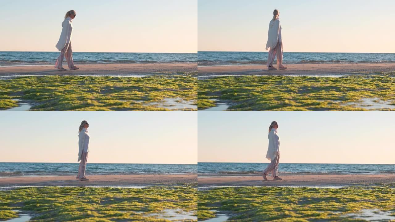 成熟的女人在海滩上享受孤独，日落
