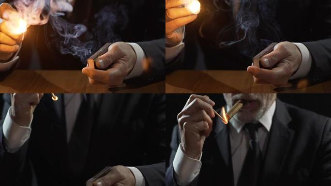 穿着昂贵西装的富人用一根火柴点燃古巴雪茄，吸烟的男性