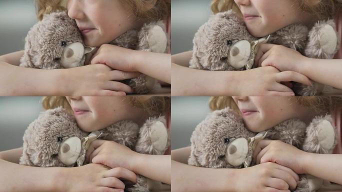 寂寞的孩子带着泰迪熊等待父母将她从孤儿院带走