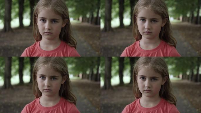 肖像悲伤的小女孩看着相机。思考好奇心的孩子在户外近距离看相机。沮丧的脸眼睛严肃沉思的孩子。童年时期的