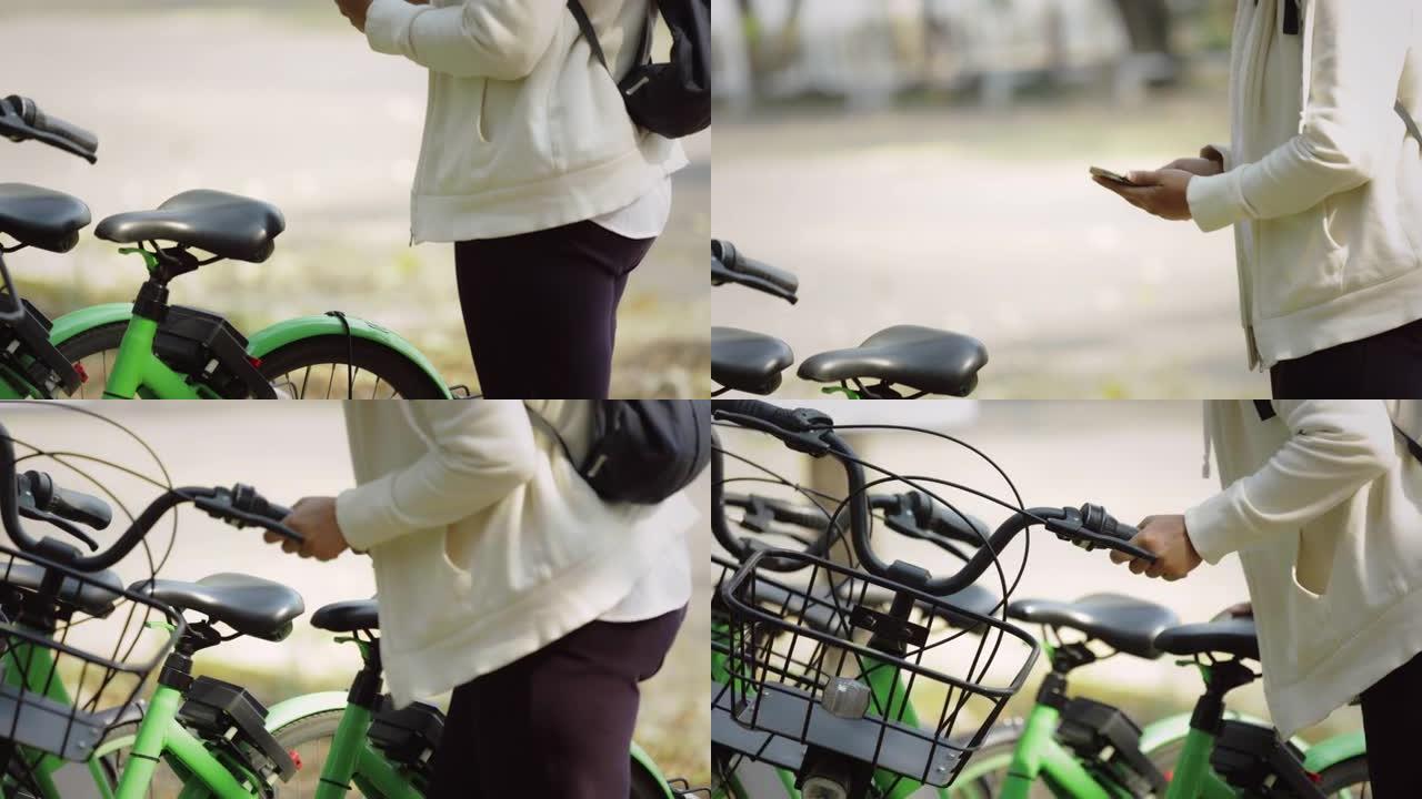 亚洲妇女正在使用手机解锁和骑公共自行车租赁服务。旅游妇女租一辆自行车在城市旅行。