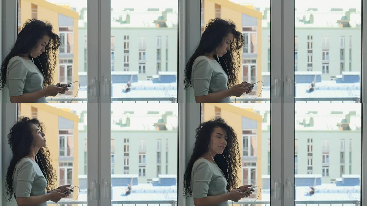 卷曲的黑发女人与在窗户附近听音乐的人传递信息