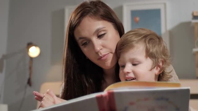 妈妈和宝宝正在读书。坐着看书的母亲和孩子的脸的前视图。特写和慢动作