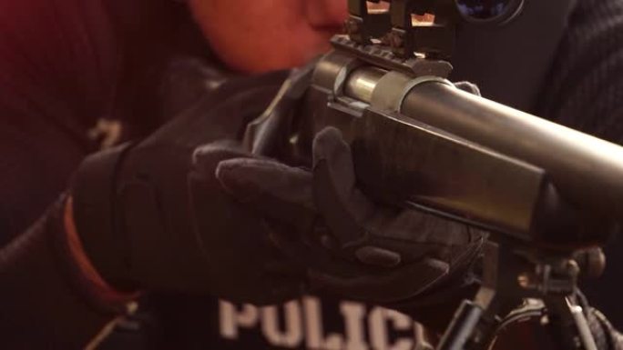 一名警察手持狙击步枪瞄准镜头，准备射击