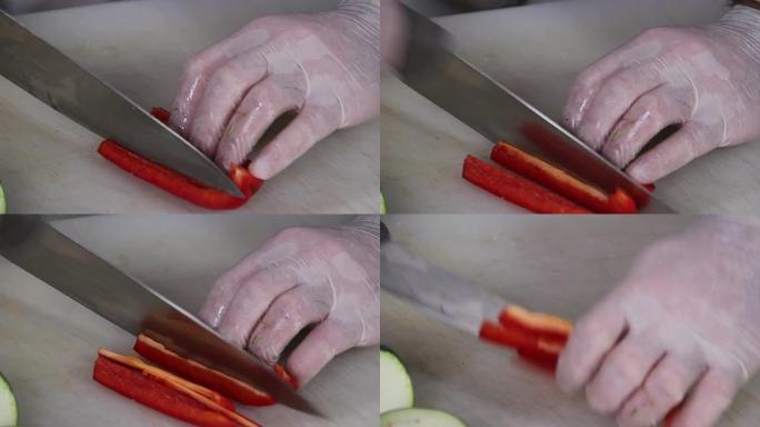 特写厨刀切碎多汁的红辣椒，烹饪过程