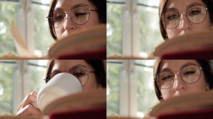 女人看书和喝咖啡。戴眼镜的女人看书，从杯子里喝咖啡或茶。特写和慢动作