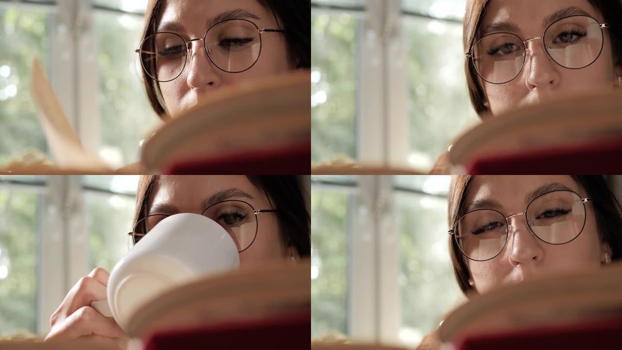 女人看书和喝咖啡。戴眼镜的女人看书，从杯子里喝咖啡或茶。特写和慢动作
