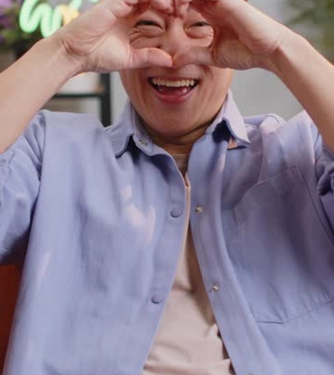 快乐的亚洲男人让爱的象征向相机展示心的迹象表达浪漫的感情