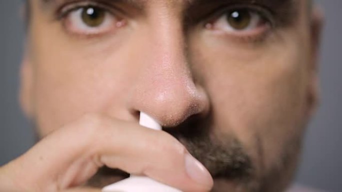 鼻炎和过敏。男人鼻子的特写镜头，男性滴鼻滴