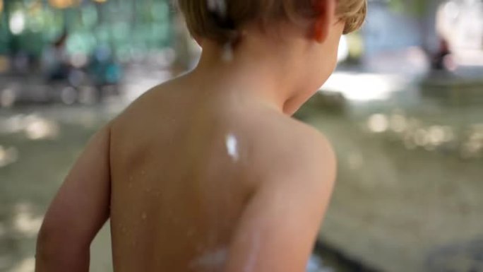 夏天，小男孩在公园外面享受清凉的水。散热概念