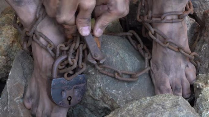 用铁链绑住奴隶的手脚。