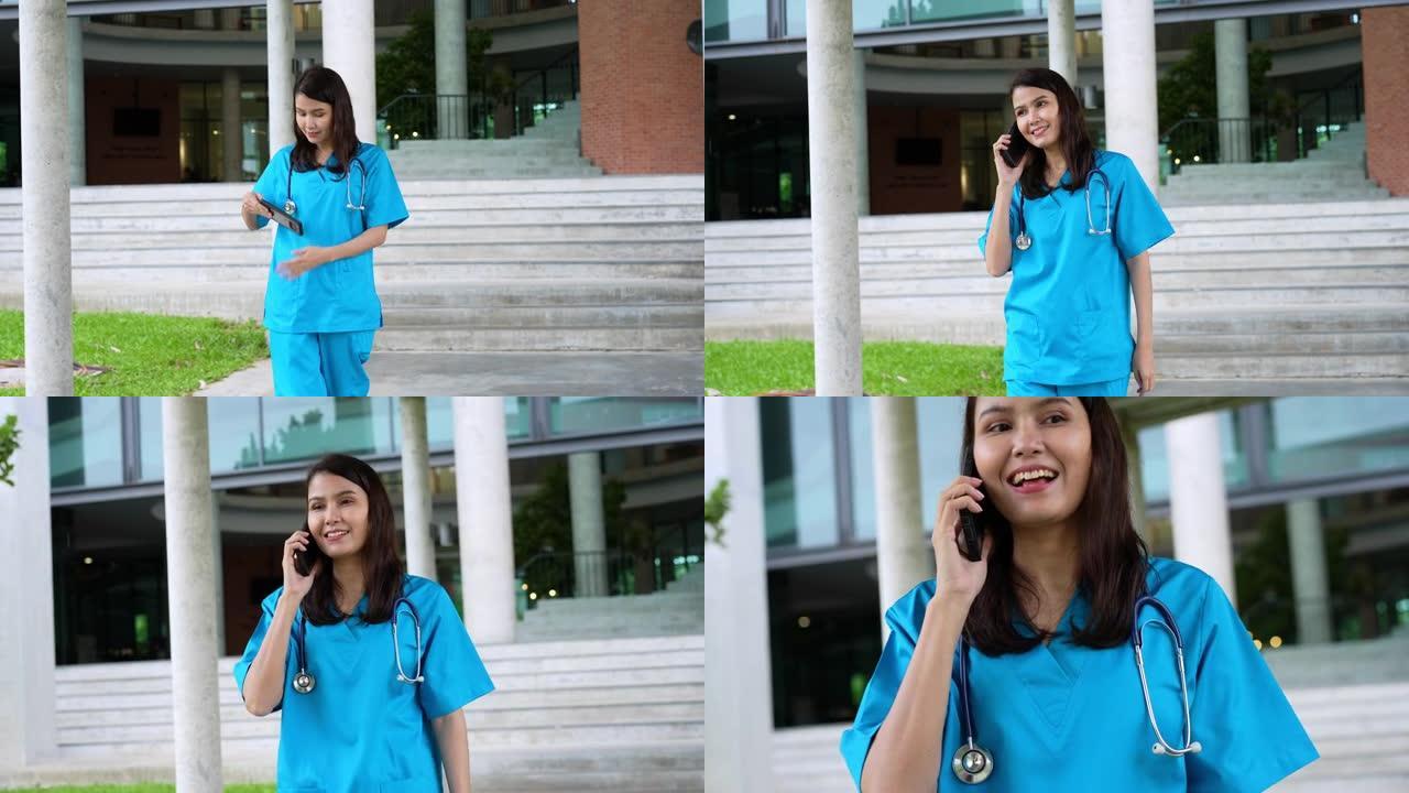 年轻的亚洲专业女医生的肖像走在大楼外，拿起智能手机向顾问咨询后，得到了一个特殊的案例，医学，保健和人