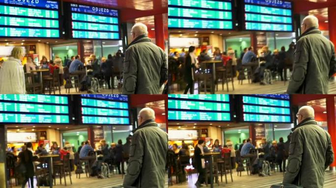 候车室的自助餐厅，戴眼镜的老人看着火车时刻表