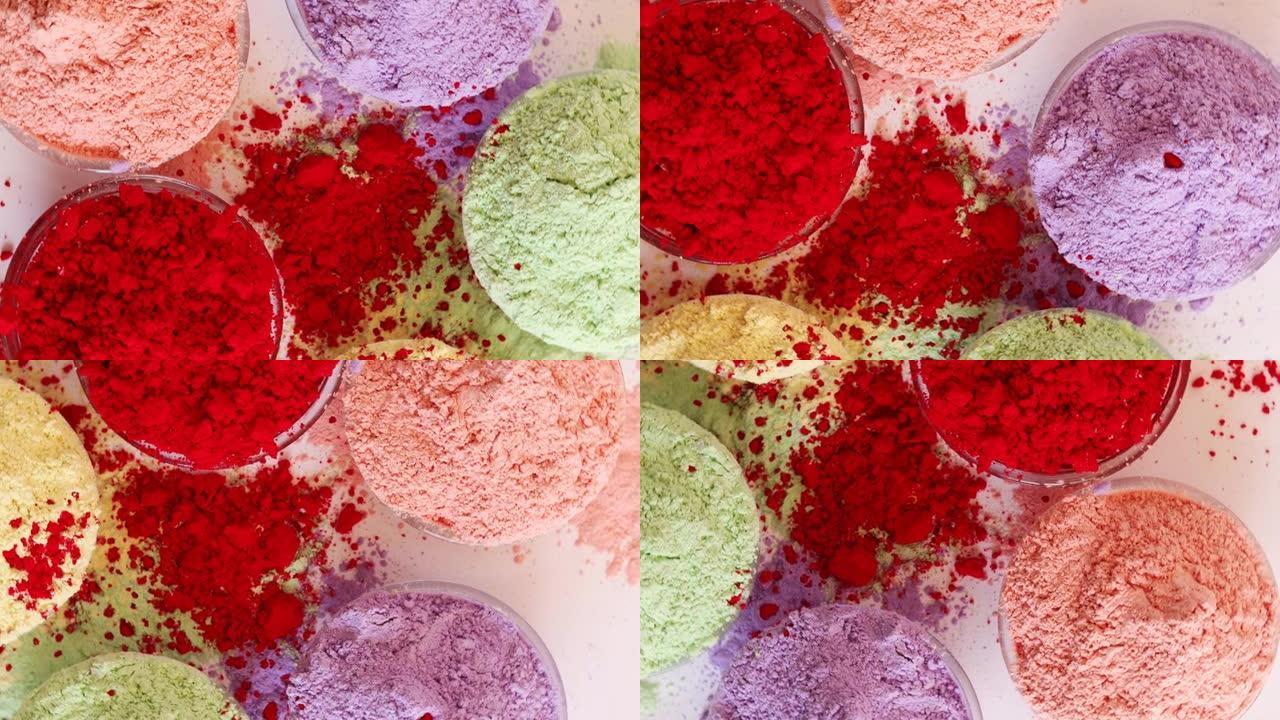 透明碗中的Holi粉末颜色桌顶视图旋转