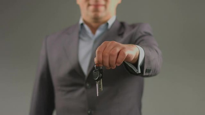 一名男子拿着汽车、公寓的钥匙。驾驶课程，彩票中奖