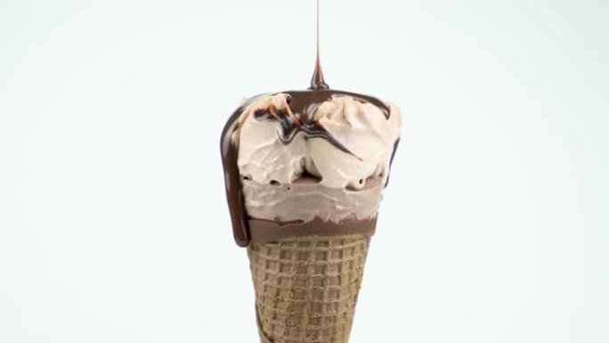 液体巧克力倒在白色背景的巧克力冰淇淋上