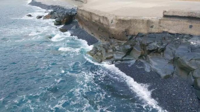 岛屿或大陆的混凝土海岸。防止海啸和大浪。海浪或海浪撞击海岸和岩石