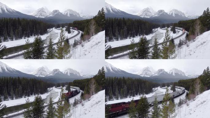 冬季在班夫国家公园，莫兰茨曲线上穿过标志性的红色货运列车穿过弓谷和落基山脉