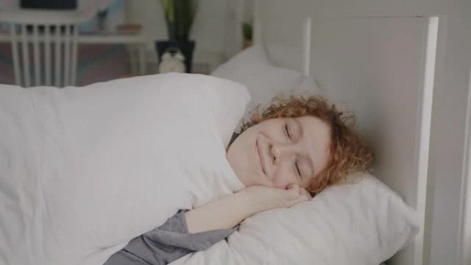 穿着睡衣的迷人年轻女士的肖像躺在床上，在家睡觉