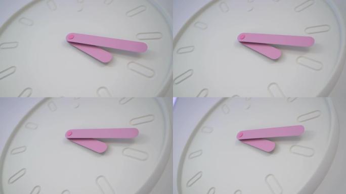 墙上挂着一个圆钟。粉红色的手显示时间-小时和分钟。