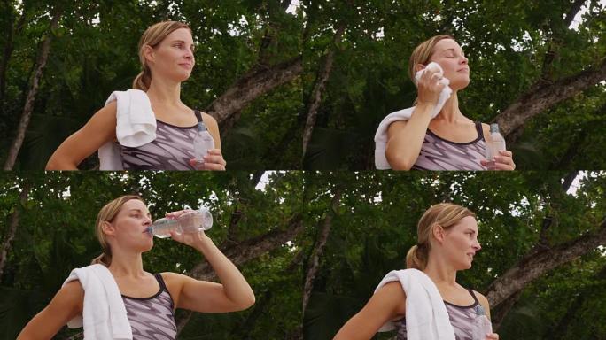 女人跑步后喝水。