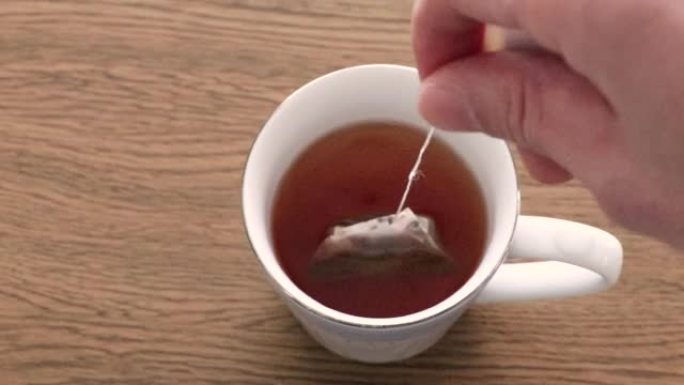 将茶包浸泡在一杯热水中