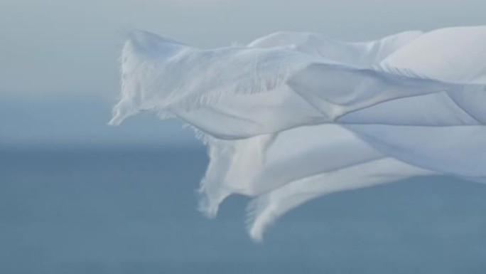 白色透明织物在海边的风中挥舞