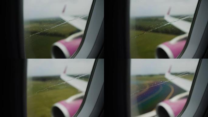 通过飞机在机场成功降落跑道的雨窗观看