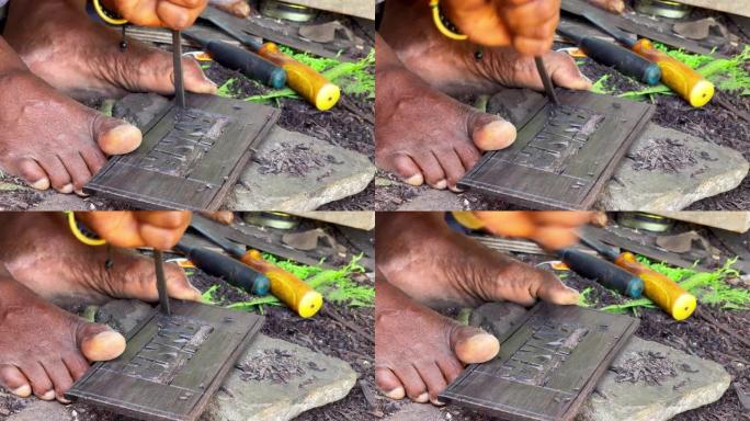 坦桑尼亚当地男子用脚趾手指拿着一块石板，用金属凿子和锤子雕刻安娜字。旅行和工匠的日常工作4k概念镜头