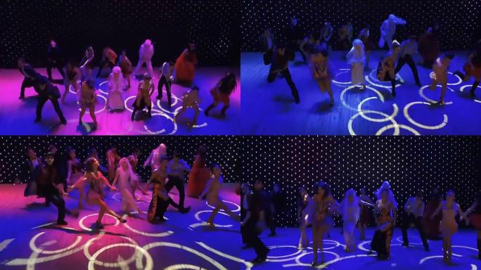 一群疯狂的舞者带着疯狂的油彩在五颜六色的舞台上跳舞