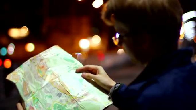 男性在旅游地图外国城市之夜寻找路线