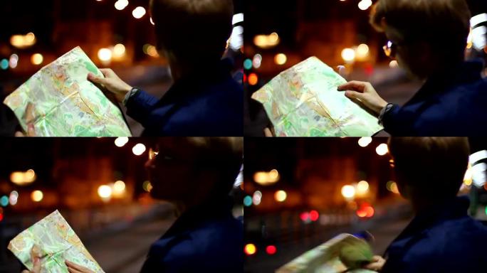 男性在旅游地图外国城市之夜寻找路线