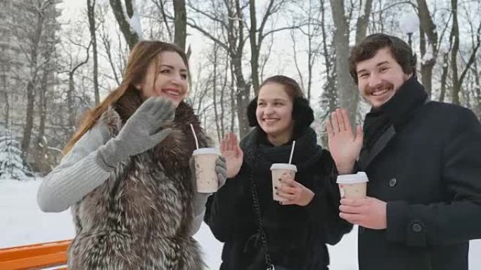 漂亮的人在冬天的白雪皑皑的公园里挥手