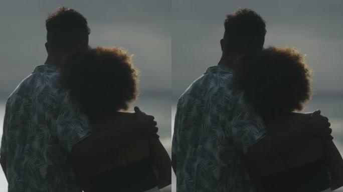 非洲族裔浪漫情侣在旷野约会。观看大海和即将到来的风暴垂直视频