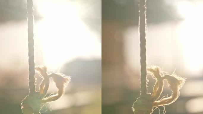在明亮的阳光背景下，一根系绳的特写镜头。