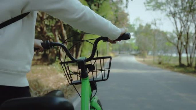 用手握把手关闭，用租赁自行车在公园里散步。旅游妇女租一辆自行车在城市旅行。城市生态交通新共享业务项目