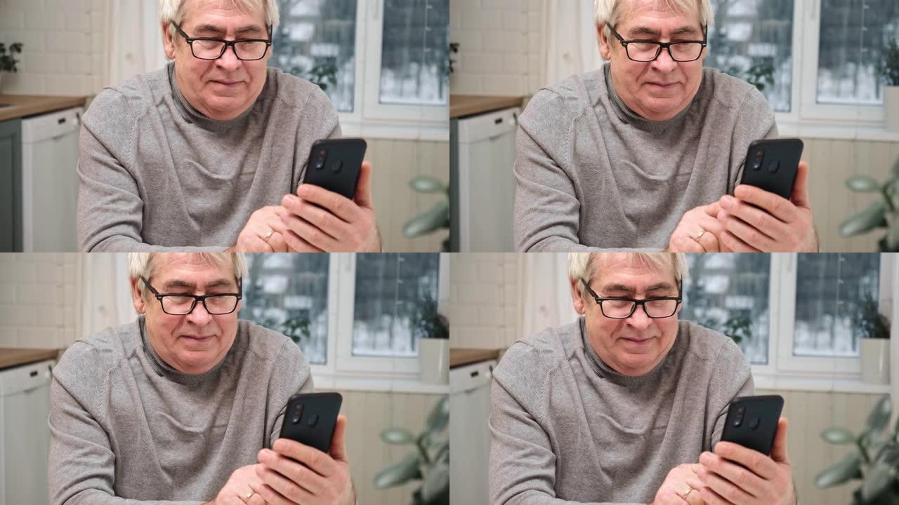 带着微笑的脸看着手机的快乐老人。他看社交网络，看新闻，玩得开心。积极的情感。坐在家里的智能手机的高级