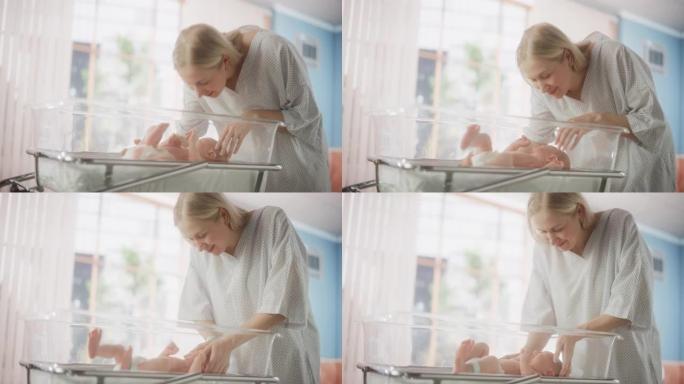 母亲与她的新生婴儿在现代托儿所诊所的医院摇篮床上建立联系。有爱心的妈妈亲吻和安慰她刚出生的孩子。医疗