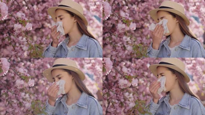 不悦的白人妇女患有过敏，而打喷嚏站在樱花树的粉红色花朵附近的白色组织。春季、季节性开花和健康状况概念