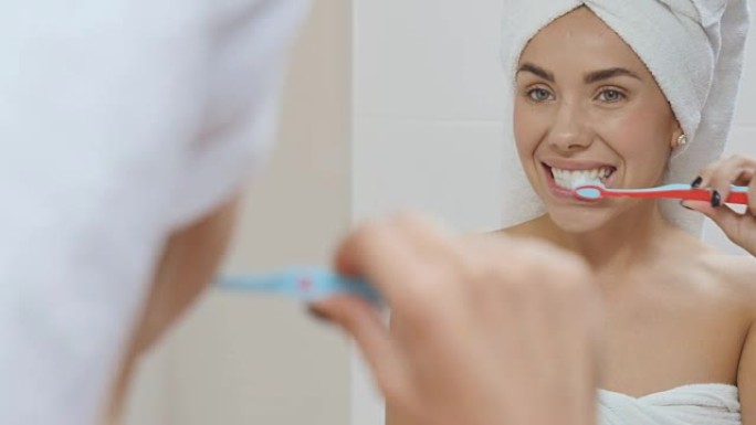浴室里毛巾上的美女在镜子前刷牙