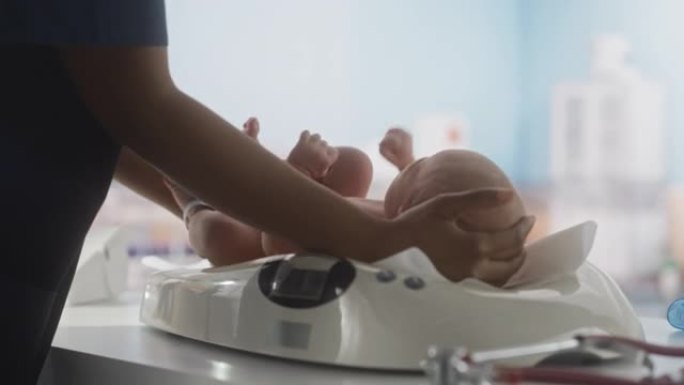 儿科医生在妇产医院病房用现代数字婴儿秤放下新生婴儿。非洲护士在托儿所出生后对孩子进行检查