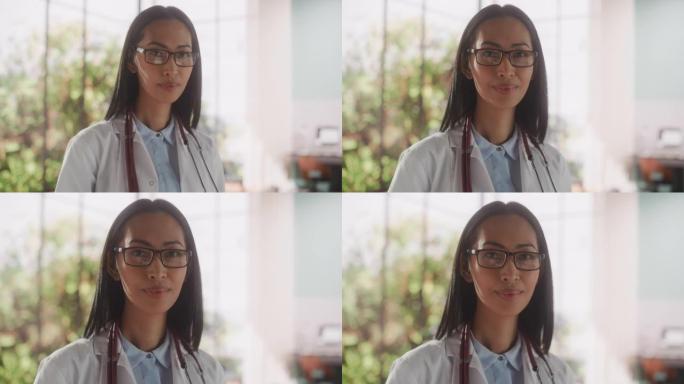 一位经验丰富的亚洲女医生穿着白大褂，在诊所里拿着平板电脑的肖像。年轻的医疗保健专业人员看着镜头轻轻微