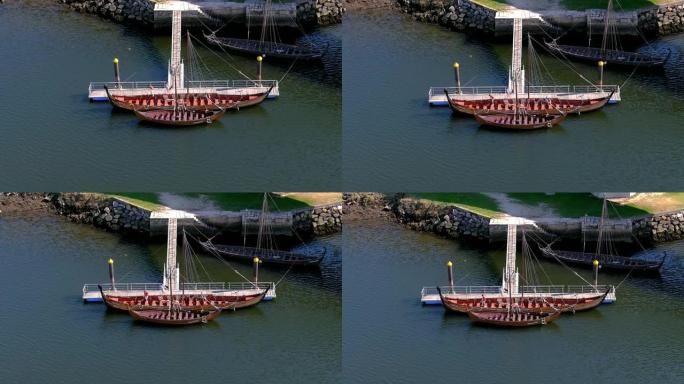 码头上的一个人在乌拉河上的一些维京展览船上，阳光明媚的夏日下午，头顶上的无人机射击。西班牙加利西亚卡