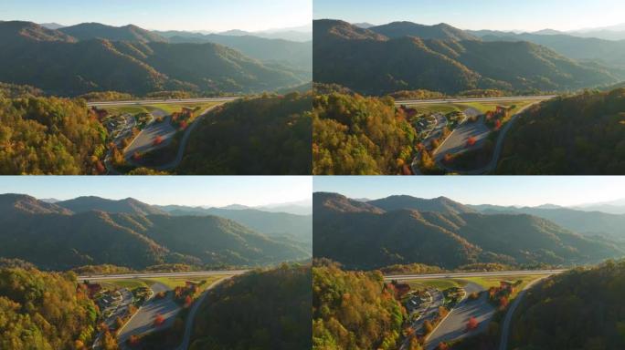 金色秋天森林之间的大型休息区的俯视图，靠近繁忙的多车道美国高速公路，有快速行驶的汽车和卡车。穿越美国