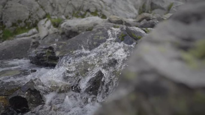 在岩石山坡上流水的详细镜头