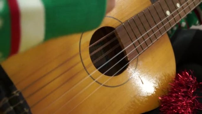 一个穿新年绿色毛衣的女孩弹木吉他